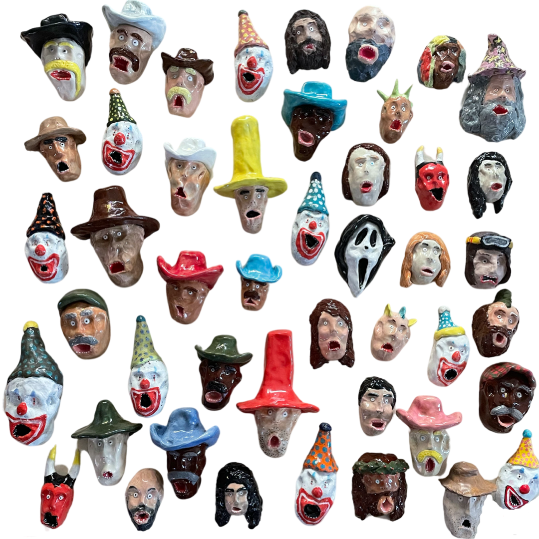 Collection of handmade ceramic face sculptures by Eddie Mellow